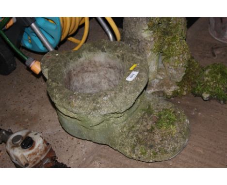 A concrete planter in the form of a shoe 