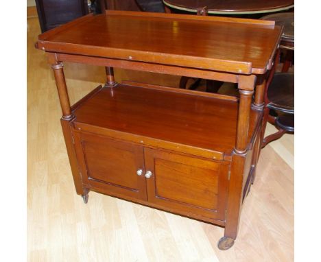 Vintage cedar traymobile top with raised borders, with turned columns to second shelf. 2 door cupboard below. On castors. H79