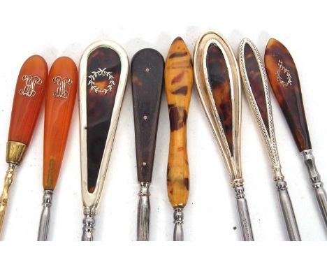 Three early 20th Century long handled silver and tortoiseshell button hooks, hallmarked for London 1919, Birmingham 1921/3, 2