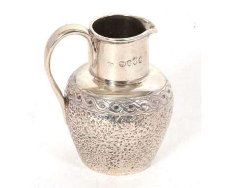 A Victorian silver small cream jug with plain polished collar and handle, the baluster body chased below a Celtic border, hal