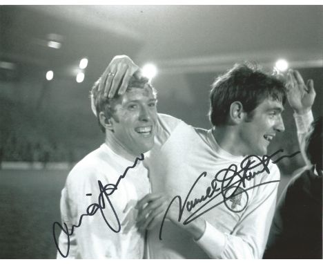 Mick Jones and Norman Hunter signed 10x8 b/w photo playing for Leeds.  Good Condition. All signed pieces come with a Certific