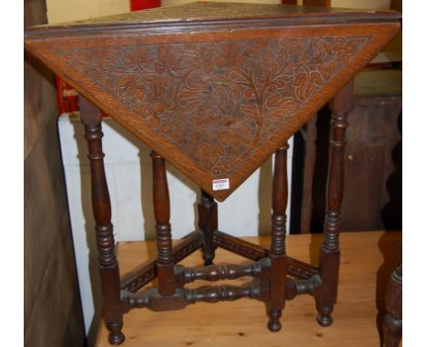 A circa 1900 floral line carved oak single drop flap corner table having a gate leg action, width 69cm