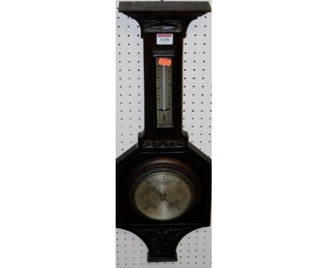 An early 20th century relief carved oak aneroid two-dial wheel barometer 