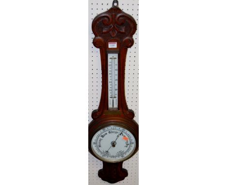 An early 20th century relief carved oak aneroid two-dial wheel barometer, with engraved brass plaque