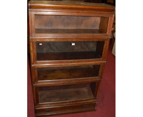 A 1930s oak Globe Wernicke type four tier stacking bookcase, having typical glazed hinged doors with single long lower drawer