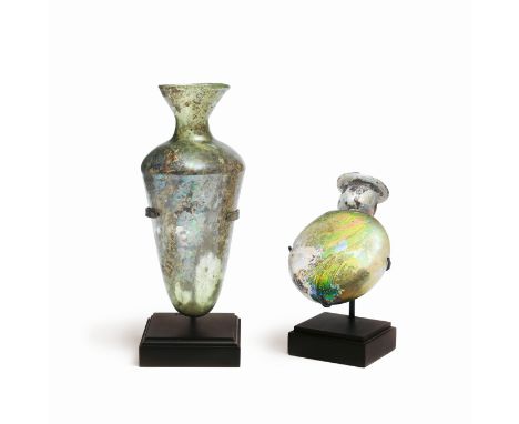  Two Roman green glass flasks Circa 2nd-4th Century A.D. Comprising a glass conical flask, with rounded shoulders and funnel 