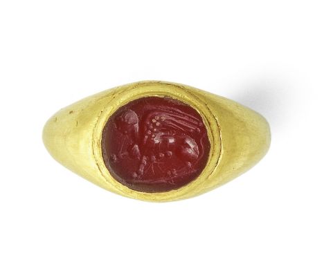  A Roman gold ring with carnelian intaglio of a sphinx Circa 1st Century A.D.The hollow gold hoop set with an oval intaglio c