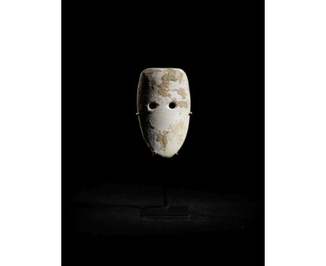  A Neolithic shell spirit mask amulet Israel, Pre-Pottery Neolithic B, circa 8000-6000 B.C.Shield-shaped, with drilled circul