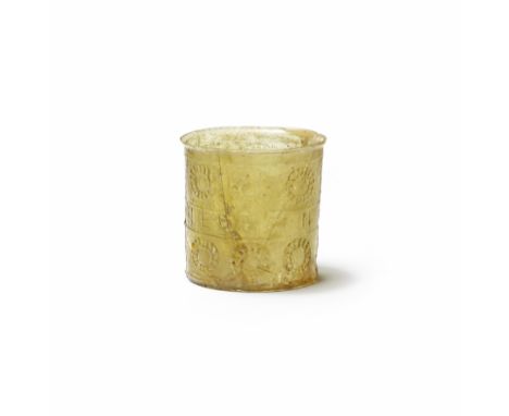  A Roman amber glass 'Victory' beaker Circa early-mid 1st Century A.D.Blown in a two-part mould, of cylindrical form with a n