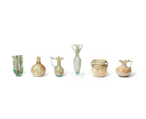  Six Roman green glass vessels Circa 4th-5th Century A.D.Comprising an amphoriskos with twin trail handles, the slender ovoid