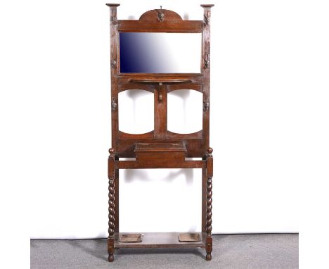 Edwardian oak hall stand, arched top above a rectangular bevelled mirror, bracket shelf, and central glove compartment flanke