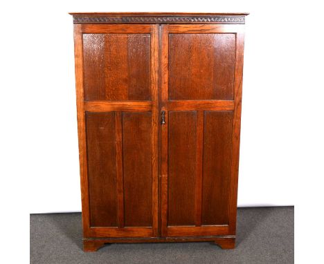 Small oak compactum wardrobe, moulded cornice above a blind key frieze, panelled doors, fitted interior, with labelled shelve