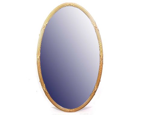A large oval gilt framed wall mirror, reeded frame, bevelled glass, 131x79cm.Condition report:Frame perhaps Edwardian, cracks