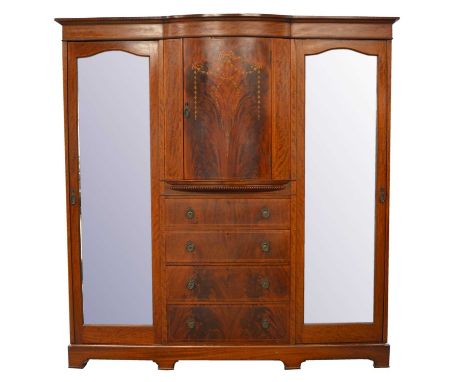 Edwardian mahogany and marquetry triple wardrobe, bowfront moulded cornice, central cupboard enclosing shelves, above four lo