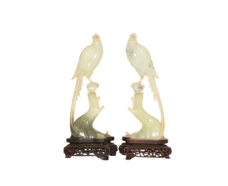 A PAIR OF CHINESE CARVED JADE MODELS OF GOLDEN PHEASANTS, each modelled perched on a tree stump and mounted on a hardwood sta