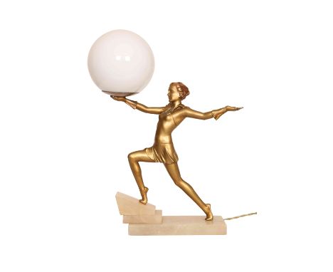 AN ART DECO FIGURAL GILT-METAL TABLE LAMP, modelled as a girl in Pierrette costume, the light fitting in her upraised right a