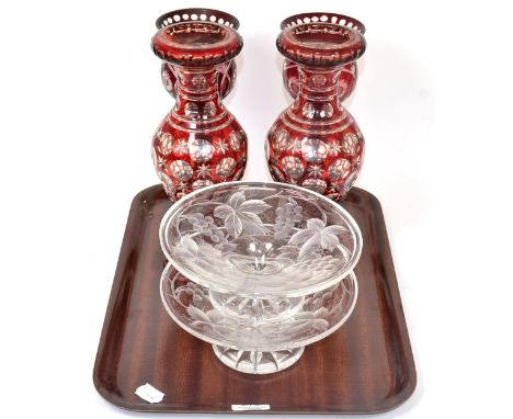A pair of ruby flashed and cut glass vases; a further pair of ruby flashed candle holders; and a pair of glass comports engra