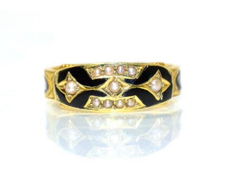 An 18 carat gold mourning ring, bands of seed pearls within black enamel, on a chased and black enamel shank, finger size O1/