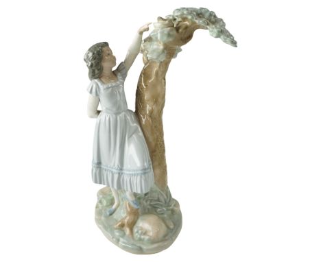 A large Nao figurine modelled as a young girl reaching to a birds nest, 1982, 31 cm