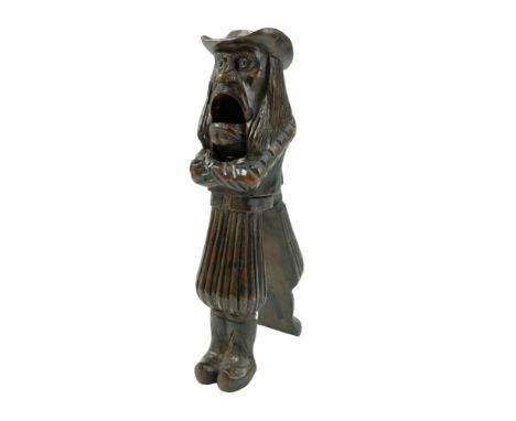 A late 19th Century French treen nutcracker in the form of a scowling figure in wide-brimmed hat, pantaloons and clogs, stamp