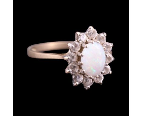 A 1980s faux opal and iolite cluster ring comprising a central oval cabochon surrounded by smaller round-cut stones, claw-set