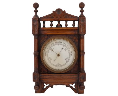 A Victorian aneroid barometer in a carved oak case, 39 cm