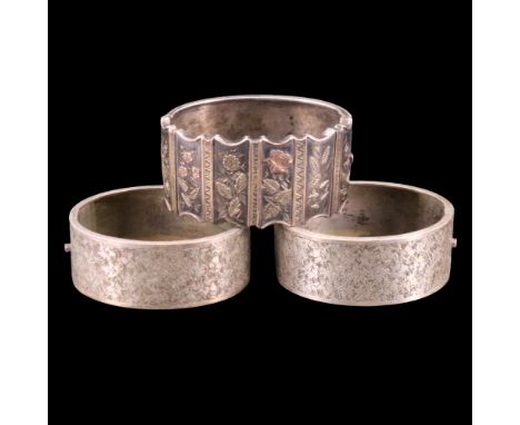 A Victorian two-colour white metal hinged bangle its obverse comprising of cusped plaques each faced with two-colour yellow m