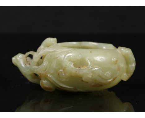 A Chinese pale green jade 18th Century peach shaped brush washer carved in high relief fruiting branches, foliage and chi-lin