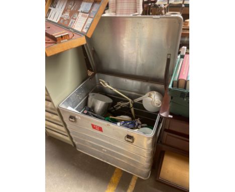 A large metal travel trunk includes angle poste lights 