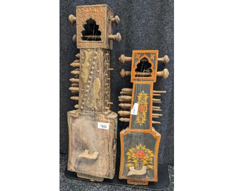 Two antique/ vintage Indian Sarangi stringed instruments. One is highly decorative with a black lacquered ground and hand pai