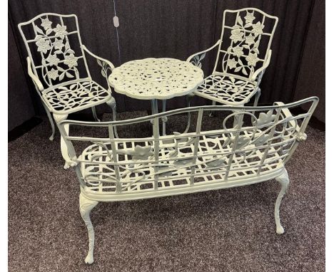 Cast metal four piece garden set; Table, bench and two single chairs. Decorated with floral design. 