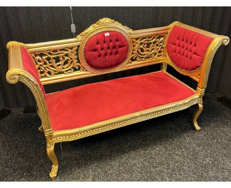 A regency style two seat window sofa. Highly detailed carved trims and panels with button back cushioned areas. Finished full