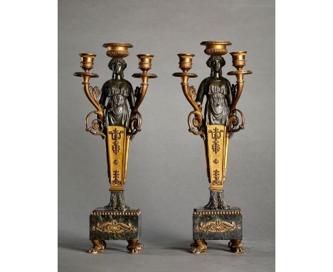 The central part forms a sheathed caryatid holding two arms of light and topped by a candlestick, resting on a square green v