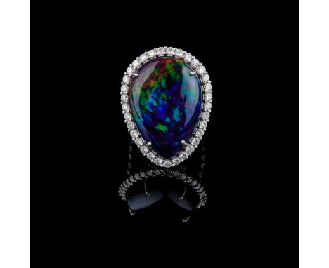 18k white gold ring centred on a pear-cut black opal weighing approximately 20 ct, surrounded by 33 diamonds, with the body s