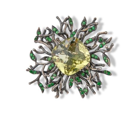 Silver ring centred on a light green cushion stonesurrounded by tsavorites.Ring size: 55Diameter of the head : 5 cmGross weig