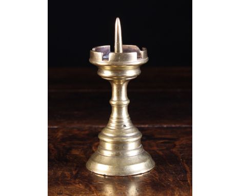 A Small 15th Century Gothic Brass Pricket Stick. The spike centring a crenulated drip pan above a ringed stem and flared base