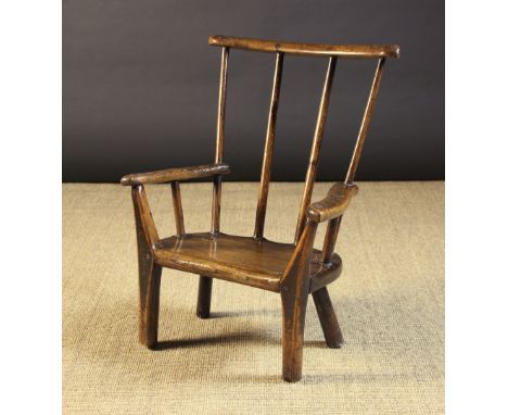 A Small 19th Century Child's Primitive Comb-back Armchair.  The bowed top rail mortised through with four long stick spindles