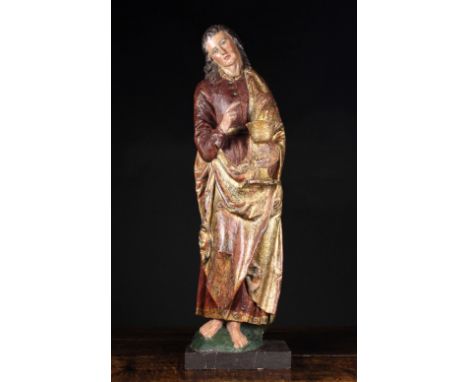 A Late 15th Century Polychromed Northern French Carving of Saint John. The barefoot figure depicted with long curly brown hai