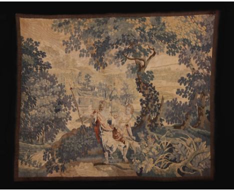 A Small Late 18th Century Tapestry of a classical couple with dog in woodland, a bridge behind them spanning a river, 45½ ins