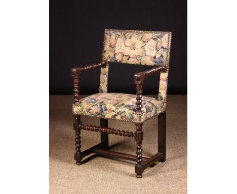 A 17th Century Franco Flemish Armchair with barleytwist supports, recovered in machine woven floral tapestry edged in brass s