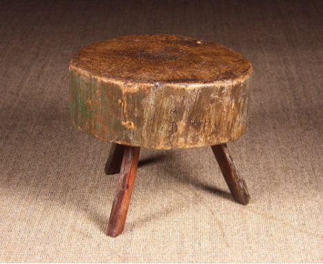 An Early 19th Century Treen Chopping Block. The thick trunk section possibly sycamore raised on three short splayed rustic le