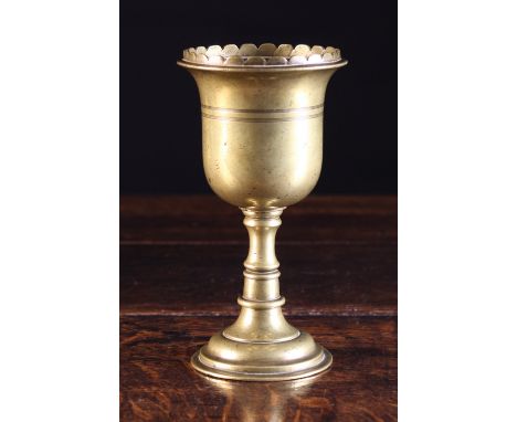 A Late 17th Century Brass Mortar/Chalice. The bell shaped bowl with a petal-cut rim and two decorative bands of incised lines