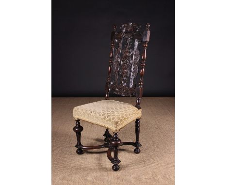 A Fine Quality Carved Walnut Chair Circa 1680 having an ornately pierced cresting rail and back splats centred by a carved ro