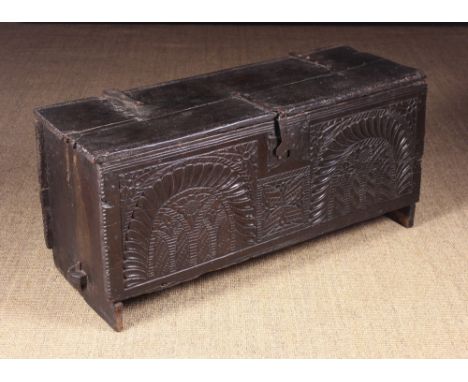 A Late Tudor Carved Oak Boarded Chest with rare tusk tenon base. The plank lid having run moulding to the front and back with