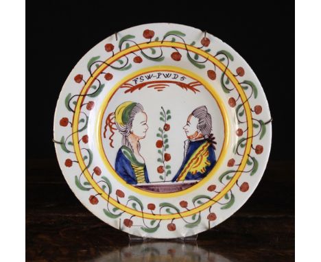An 18th Century Polychrome Delft Plate decorated with a charming double portrait of man & woman facing each other below the i