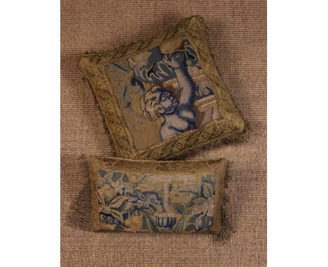 Two Small Cushions covered in fragments of 17th century tapestry bordered with metallic gold braid and edged in fringing, one