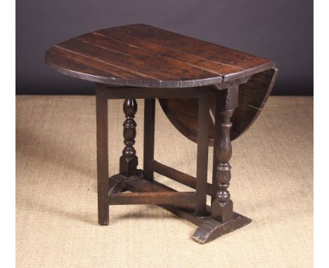 A Small Charles II Oak Drop-Leaf Table.  The oval top on baluster, ball and reel turned end supports leading down to sledge f