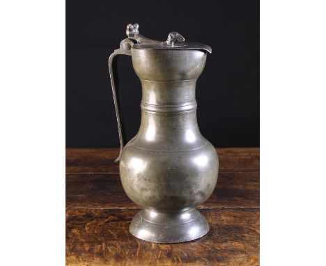 A Large 17th Century Swiss Pewter Flagon. The flat heart-shaped lid surmounted by a rams head finial and having a twin acorn 