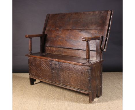 A 17th Century & Later Monk's Bench/Table converted from a boarded oak coffer.  The twin plank top on peg hinges pivoting to 