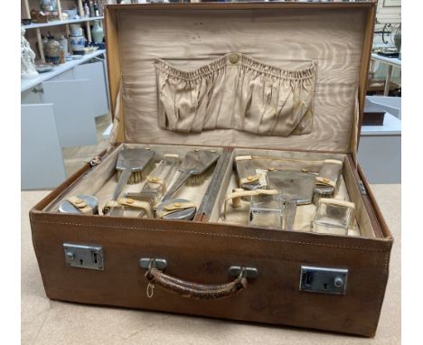 A 1930's Art Deco leather travelling toilet case, containing eleven silver mounted jars, mirror, and brushes, Adie Bros. Birm